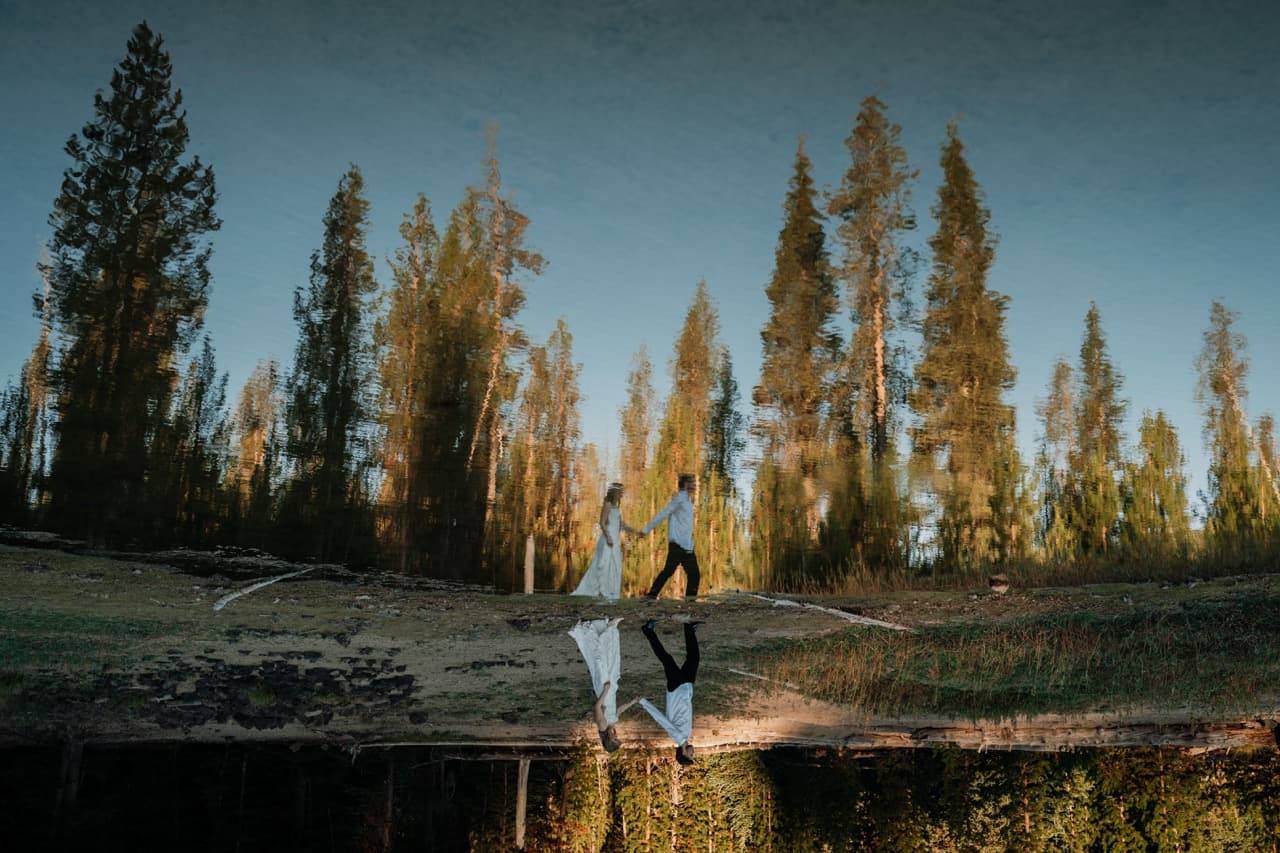 Couple walking, reflected in still water
